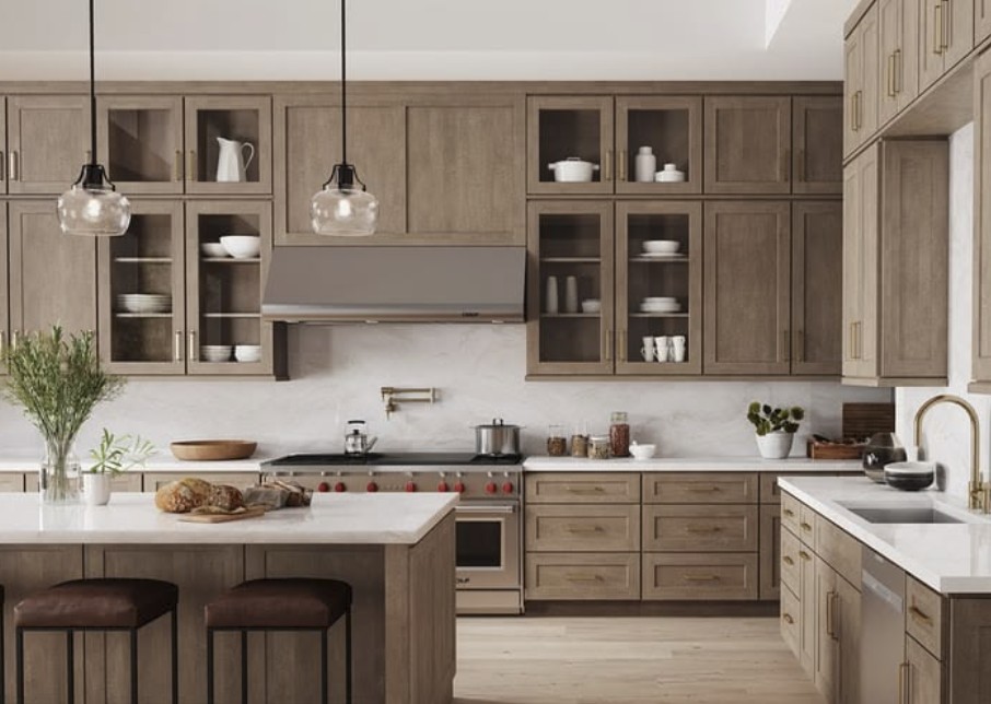 A warm oak inset kitchen with glass-front uppers, white quartz counters, and a large island